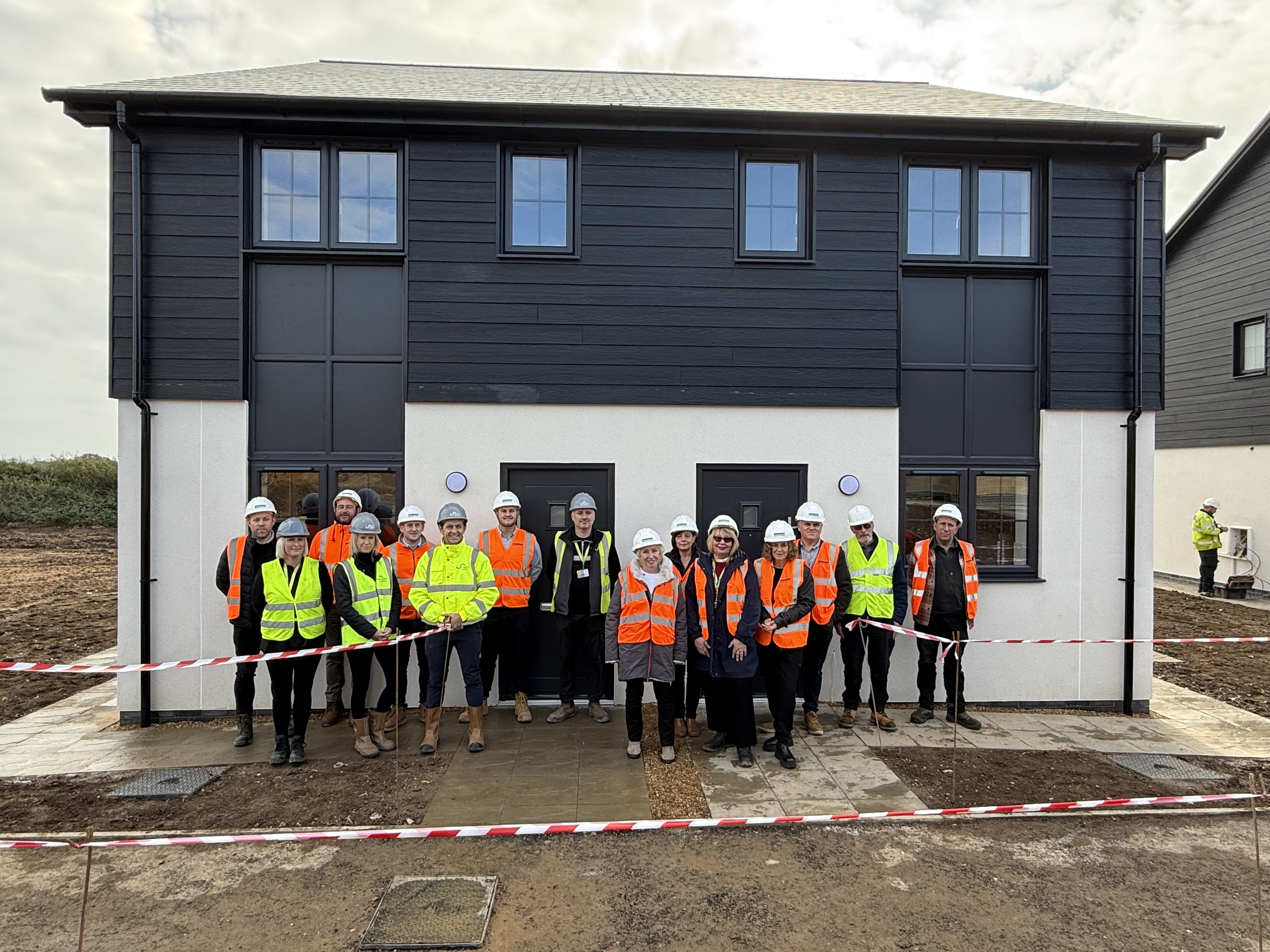 Members of North Norfolk District Council, Homes for Wells, Flagship Homes and Munnings Construction outside homes at the Stiffkey Road site in Warham