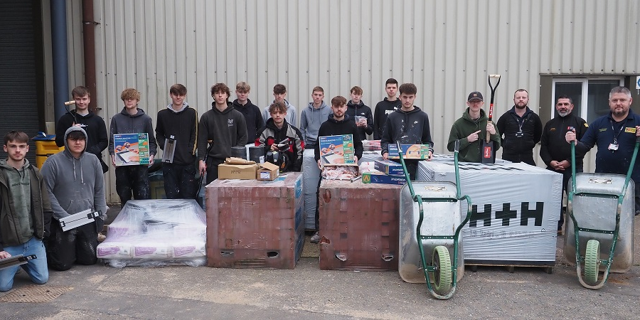 students of West Suffolk College pose with the materials and tools donated by Flagship Group and Travis Perkins