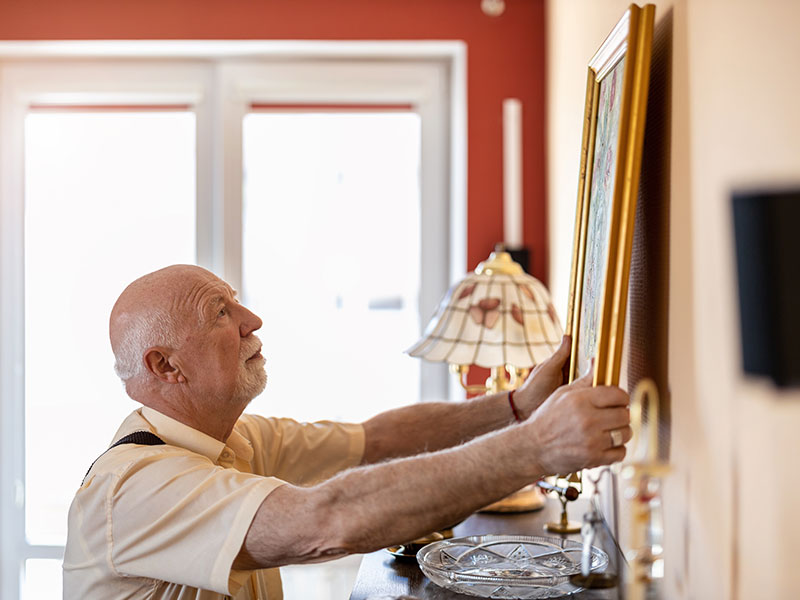 photo of man putting up a picture
