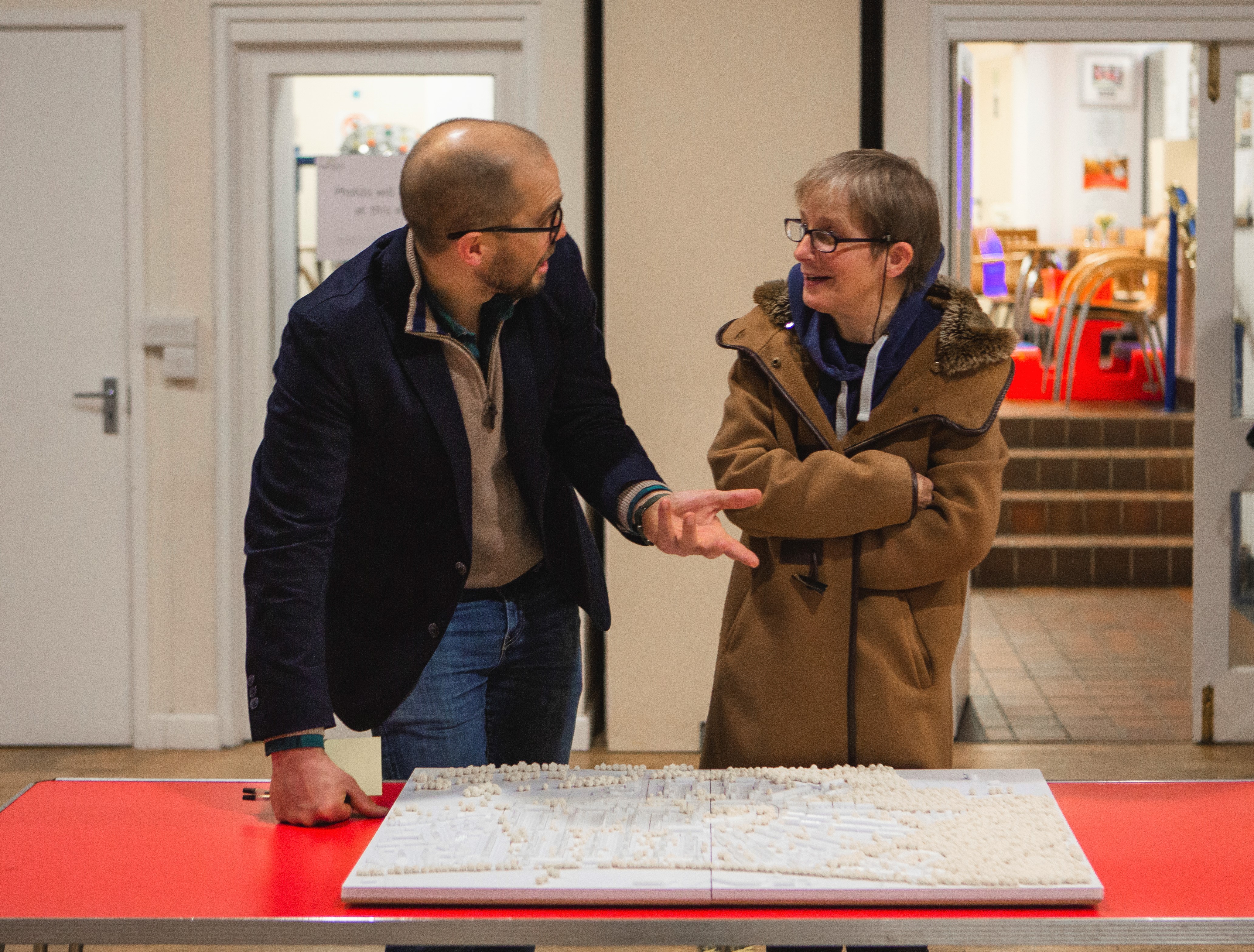 Two people talking while looking at estate map